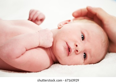 Little Newborn Baby Lying On White Blanket And Under Adult Hand Protection