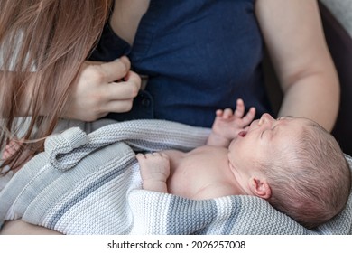 A little newborn boy is crying in her mother's arms, a hungry baby is crying, a woman is lactating.
