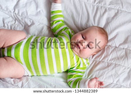 The little newborn girl lies on the bed. Dad does her masses. The child has overweight, obesity.