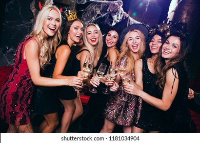 Little party never killed nobody! Beautiful young women in evening gown looking at camera and drinking champagne with smile while celebrating Halloween in nightclub
 - Powered by Shutterstock