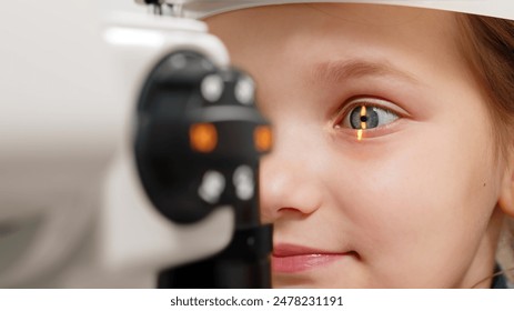 A little patient undergoes an eye test by a professional optometrist using modern diagnostic equipment in an ophthalmology clinic. - Powered by Shutterstock