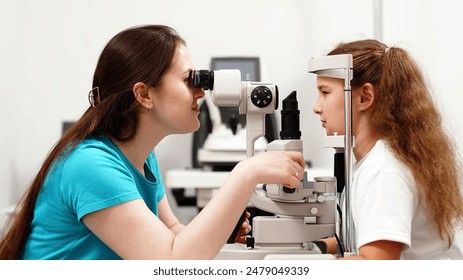 A little patient undergoes an eye test by a professional optometrist using modern diagnostic equipment in an ophthalmology clinic. - Powered by Shutterstock