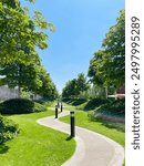 Little pedestrian pathway in the park with green trees