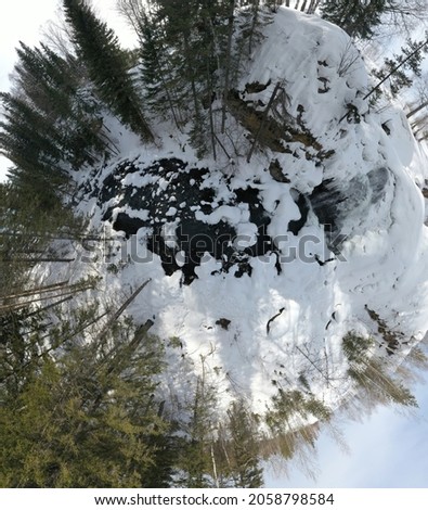 little planet small planet  panoramic aerial view waterfall on small mountain river in winter forest with snow-covered trees