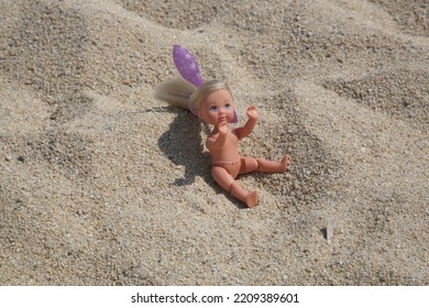 Little Plastic Doll On The Sand Beach	