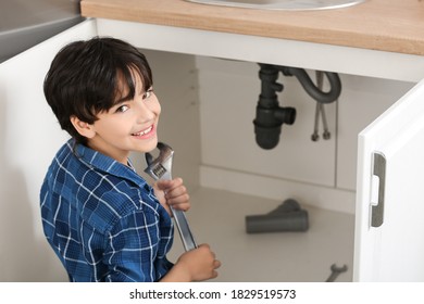 Little Plumber Repairing Sink In Kitchen