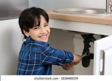 Little Plumber Repairing Sink In Kitchen