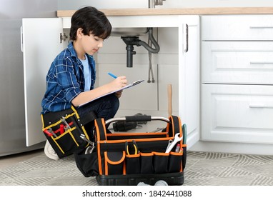 Little Plumber Repairing Sink In Kitchen