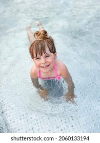 Little Preschool Girl Splashing In An Outdoor Swimming Pool On Warm Summer Day. Happy Healthy Toddler Child Enjoying Sunny Weather In City Public Pool. Kids Activity Outdoors With Water.