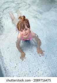 Little Preschool Girl Splashing In An Outdoor Swimming Pool On Warm Summer Day. Happy Healthy Toddler Child Enjoying Sunny Weather In City Public Pool. Kids Activity Outdoors With Water.