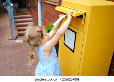 Little Preschool Girl Throwing Letter In A Mailbox. Excited Child Writing Card Or Letter For Grandparents Or Family. Old Fashioned Way Of Communication.