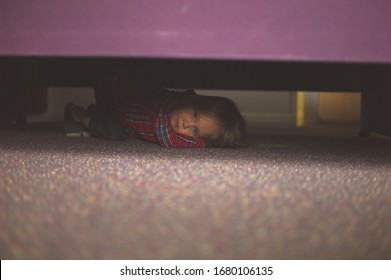 A Little Preschooler Is Hiding Under The Bed