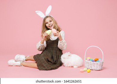 Little Pretty Blonde Kid Girl 11-12 Years Old In Spring Dress Hold Fluffy White Bunny Rabbit Isolated On Pastel Pink Background Children Studio Portrait. Childhood Lifestyle Happy Easter Concept