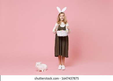 Little Pretty Blonde Kid Girl 11-12 Years Old In Spring Dress Hold Fluffy White Bunny Rabbit Isolated On Pastel Pink Background Children Studio Portrait. Childhood Lifestyle Happy Easter Concept