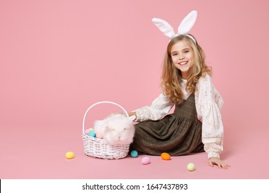 Little Pretty Blonde Kid Girl 11-12 Years Old In Spring Dress Hold Fluffy White Bunny Rabbit Isolated On Pastel Pink Background Children Studio Portrait. Childhood Lifestyle Happy Easter Concept