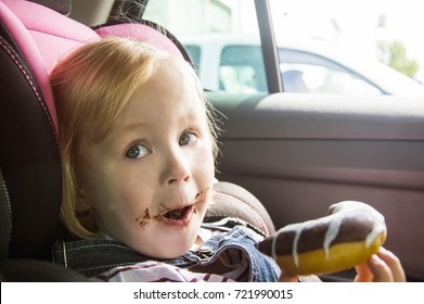 Little Pretty Girl Eating Chocolate Donuts In Car Salon