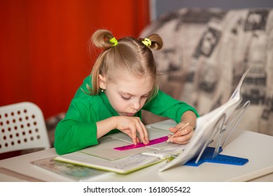 little pretty girl with poor posture, slouching, 7-8 years old, first grader, at her desk, doing homework, teaching lessons, drawing on the line