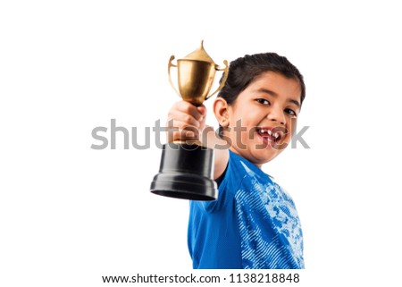 little pretty indian/asian girl with an award, holding a trophy with success and proud expression, isolated over white background