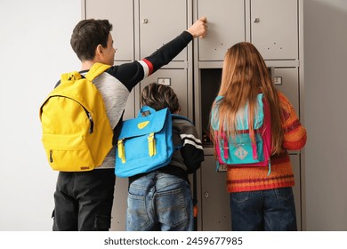 Little pupils opening their lockers at school, back view - Powered by Shutterstock