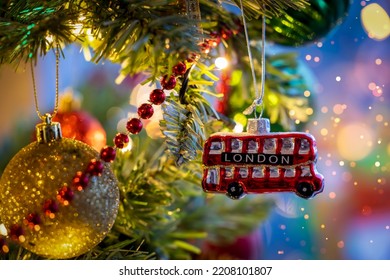 A little, red double decker bus from London as a christmas ornament on a illuminated tree with selective focus - Shutterstock ID 2208101807