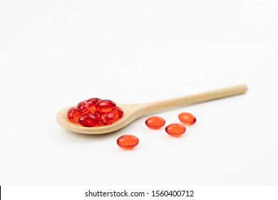 Little Red Soft Gel Vitamin Supplement Capsules On Wooden Spoon