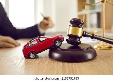 Little Red Toy Automobile On Table With Sound Block And Gavel. Small Car Model On Wooden Desk With Judge's Hammer. Car Accident, Drunk Driving, Lawsuit, Court Of Law, Justice, Lawyer Services Concept