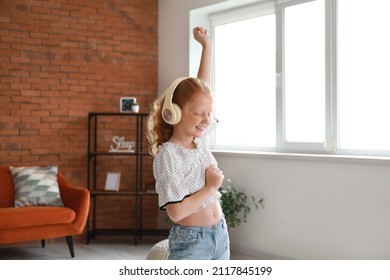 Little Redhead Girl In Headphones Dancing At Home