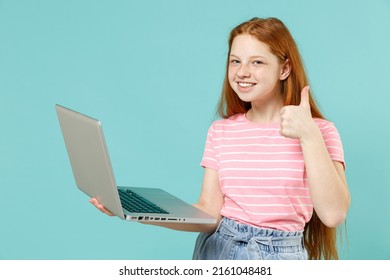 Little redhead kid girl 12-13 years old in pink striped t-shirt hold laptop pc computer chat social network show thumb up isolated on pastel blue background studio Children lifestyle childhood concept - Shutterstock ID 2161048481