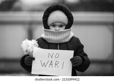 Little refugee girl with a sad look and a poster that says no to war. Social problem of refugees and internally displaced persons. Russia's war against the Ukrainian people.