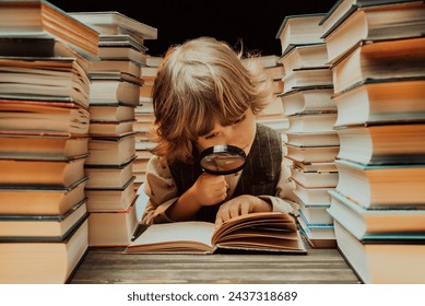 Little researcher boy reads book with magnifying glass in library. Cute clever preschooler playing, studying knowledge with instrument. High quality - Powered by Shutterstock