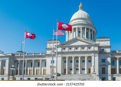 LITTLE ROCK, AR USA – FEBRUARY 20, 2022: The Arkansas and American flags are in front of the Arkansas State Capitol Building in Little Rock. 