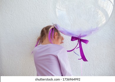 Little Sad Girl With Purple Balls. The Baby Is Crying And Upset At His Birthday