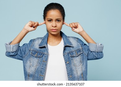 Little Sad Serious Kid Teen Girl Of African American Ethnicity 12-13 Years Old In Denim Jacket Cover Ears With Hands Fingers Do Not Want To Listen Scream Isolated On Pastel Plain Light Blue Background