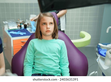 Little scared girl sitting in chair in dentist doctor office. Kid,child afraid of tooth extraction, teeth treatment, examine with open mouth. Dental clinic check-up. Reclined position. Dentist gloves. - Powered by Shutterstock