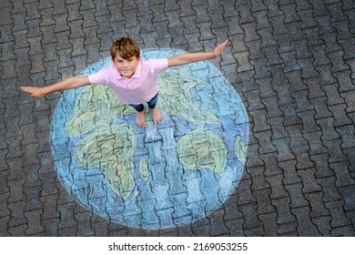 Little school boy with earth globe painting with colorful chalks on ground. Positive kid child. Happy earth day concept. Creation of children for saving world, environment and ecology. - Shutterstock ID 2169053255