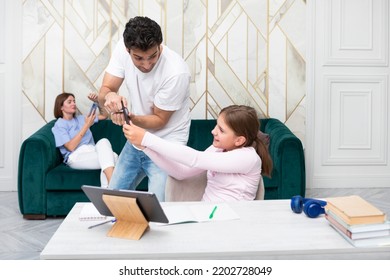 Little School Girl Studies At Home And Her Serious Dad Taking Away Her Smartphone Because She Gets Distracted While Studying