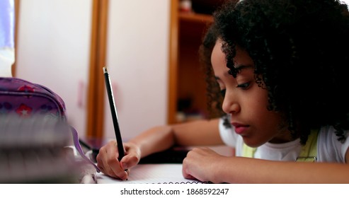 Little School Girl Studying At Home Writing Notes. Black Mixed Race Ethnicity Child Homework.