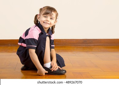 Little School Girl Tying Her Black Shoes