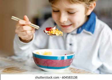 Little School Kid Boy Eating Cereals With Milk And Berries, Fresh Strawberry For Breakfast Or Lunch. Healthy Eating For Children, Schoolkids. At School Canteen Or At Home. Selective Focus