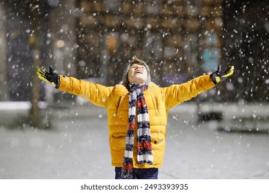 Little school kid boy of elementary class walking to school during snowfall on early dark morning. Happy healthy child having fun and playing with snow. Schoolkid in colorful winter clothes. - Powered by Shutterstock