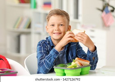 Little schoolboy eating tasty lunch in classroom - Powered by Shutterstock