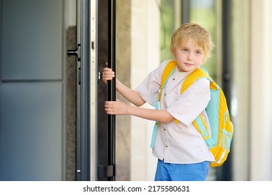 Little schoolboy leaves the house to go to school after holiday. Child in a yard of schoolhouse. Quality education for children. Kids back to school concept. - Shutterstock ID 2175580631