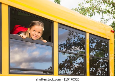 Little Schoolgirl Looking Through A Schoolbus Window