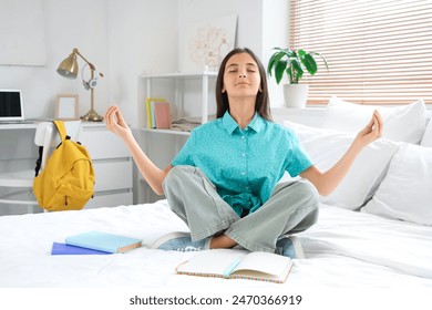 Little schoolgirl meditating while studying in bedroom - Powered by Shutterstock