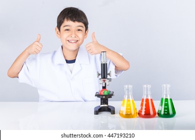 Little scientist boy with microscope and colorful flask on white table

 - Powered by Shutterstock