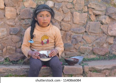 Little Serious Native American Girl Holding Plate With Dinner Outside.