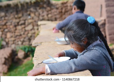 Little Serious Native American Girl Holding Plate With Dinner Outside.