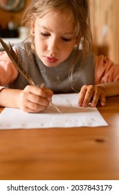 Little Seven Year Old Kid Girl Draws A Disappearing Drawing On A Paper With A Real Sharpened Duck Pen Using Milk Instead Of Ink