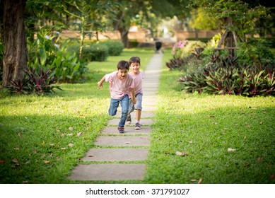 Little Sibling Boy Playing Together In The Park