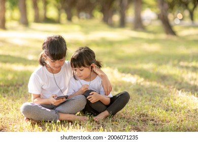 Little sibling girls listening music with headset happy together - Powered by Shutterstock